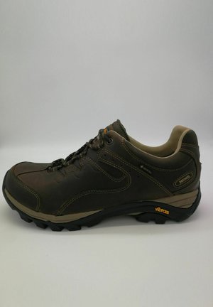 Brauner Wanderschuh mit Vibram-Sohle, Gore-Tex-Label, gepolstertem Kragen und Schnürdesign auf einfarbigem Hintergrund.