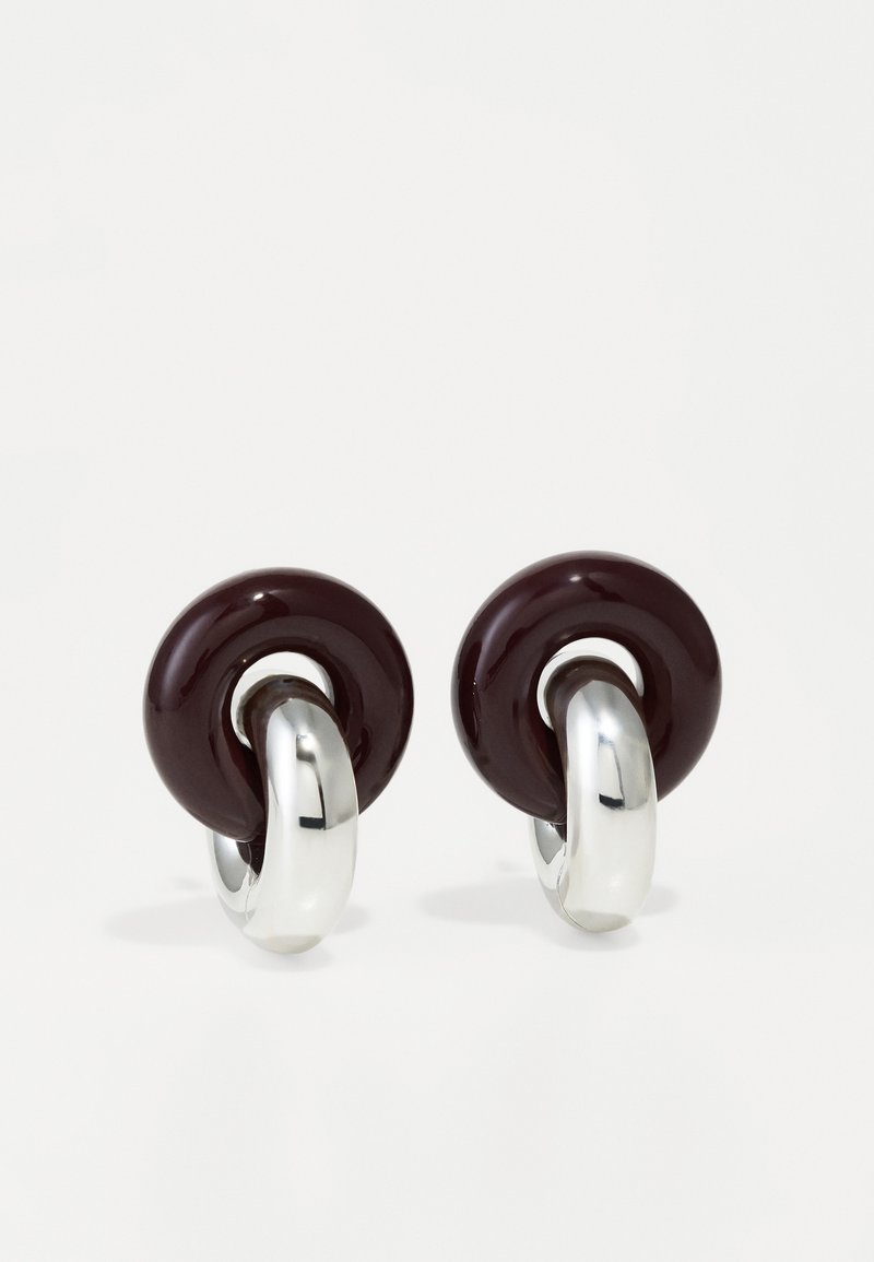 Pendientes circulares con tapas de resina burdeos oscuro y hardware plateado brillante, que presentan una textura suave y un diseño de bucle redondeado.
