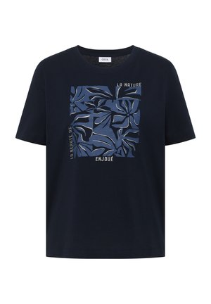 T-shirt bleu marine à manches courtes avec un motif floral abstrait carré dans des tons de bleu et un texte en français sur le devant.