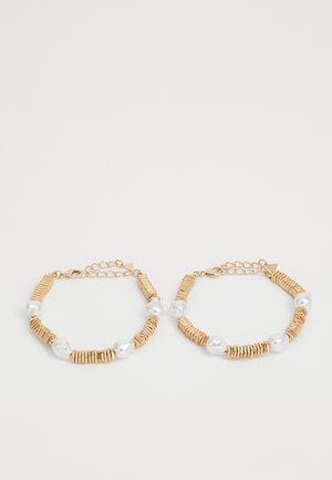 Kuldtooni käevõrud, kus vahelduvad lamedad metall- ja naturaalsest pärlist helmed. Sisaldab reguleeritavaid ahelaid suuruse kohandamiseks.