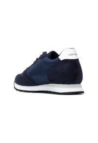 Marineblauwe sport schoen van suede en glad leer. Witte hielaccent. Verhoogde zool met een getextureerde zwarte rubbere buitenzool.