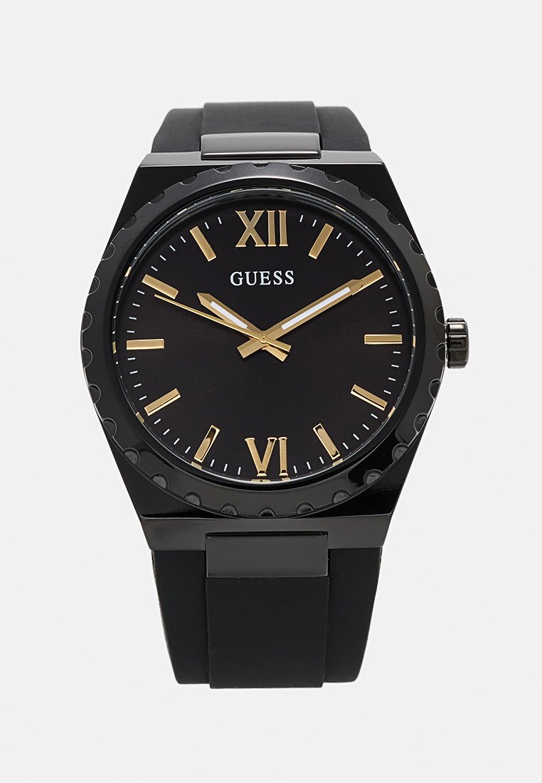 Reloj analógico negro con una esfera redonda, marcadores de hora dorados y una correa de silicona. Presenta un bisel suave y un logotipo de marca prominente.