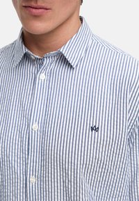 Gestreept overhemd met knopen in blauw en wit, gemaakt van katoen. Heeft een puntige kraag, twee knopen en een klein geborduurd logo op de borst.