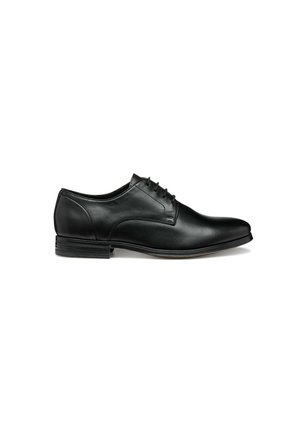 Zapato de vestir de cuero negro con un acabado suave, punta redondeada y seis ojales para los cordones. Presenta un tacón bajo y apilado, además de un diseño minimalista.