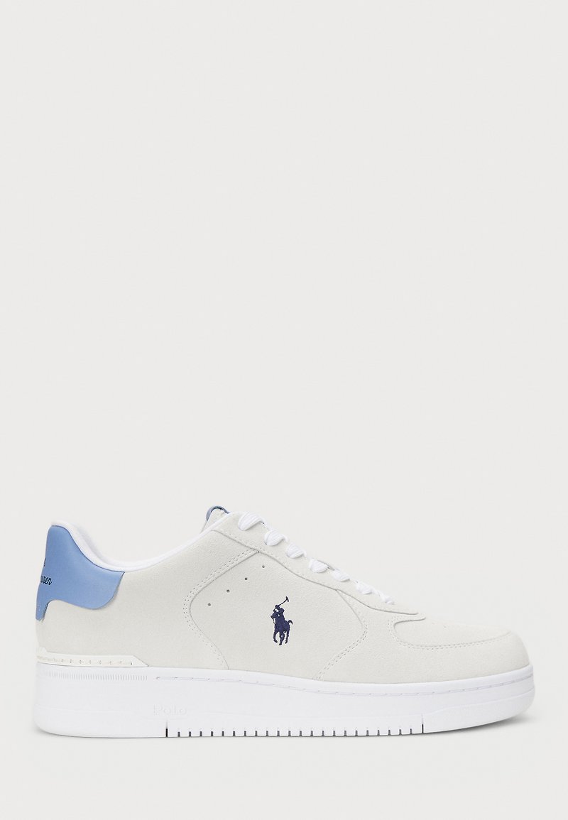 White suede sneakers with a blue accent on the heel, featuring a purple logo. Lace-up design with perforated details on the sides.