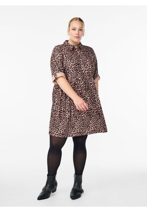 Short-sleeve, A-line dress in light pink with a black leopard print. Features a buttoned collar and is paired with black ankle boots.