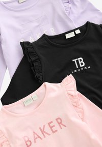 Tres camisetas en lavanda, negra y rosa. Cada una tiene diferentes estilos de texto: la lavanda presenta un estampado plateado, la negra tiene mangas acampanadas y la rosa tiene lentejuelas.