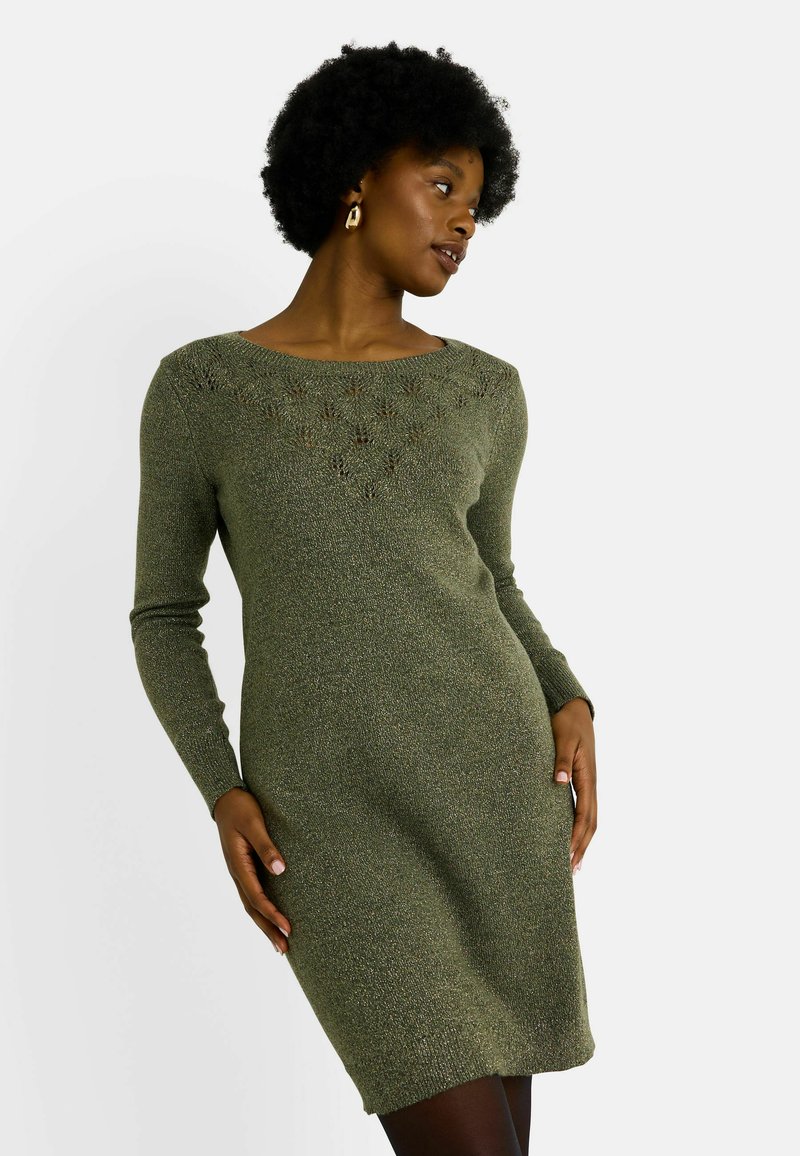 Vestido de punto en verde oliva con mangas largas, escote en forma de barco y detalles de encaje en el pecho. Textura suave, estilo ajustado, hasta la rodilla.