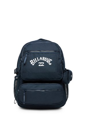 Zaino Billabong blu scuro con più scomparti con cerniera, tasche laterali in rete e una piccola tasca attaccata sul lato.