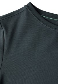 Tmavě zelená košile s krátkým rukávem a kulatým výstřihem. Vyrobena z hladké, lehké tkaniny s jemnými švy podél švů.