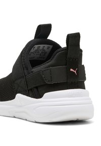 Zapatilla de malla negra con suela blanca, tirador trasero, correa ajustable y logotipo de Puma en rosa en el lazo del talón.