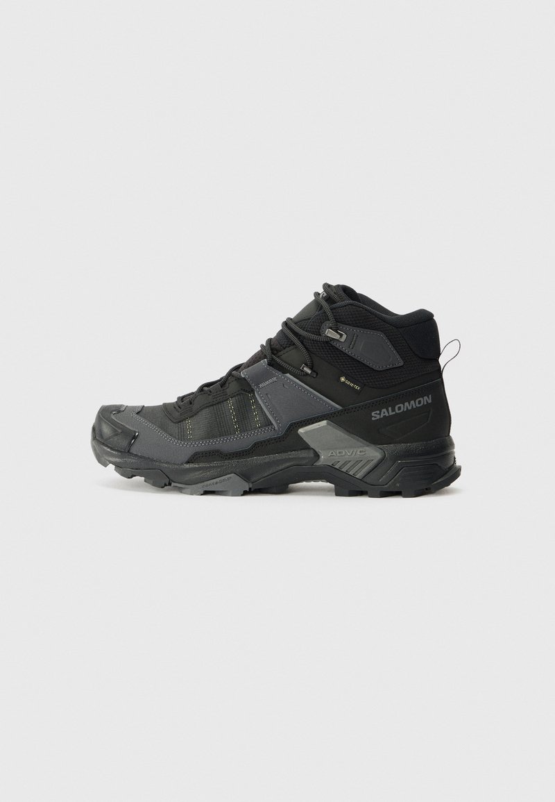 Botas de caminhada de cano alto em preto e cinza, com um cabedal em malha texturizada, biqueira reforçada e uma sola de borracha robusta com sulcos profundos.