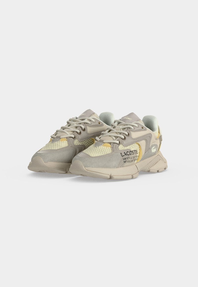 Coppia di sneaker Lacoste beige e giallo chiaro con pannelli in mesh e suede, suole spesse e loghi marchiati sul lato e sulla linguetta.