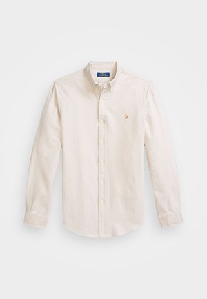 Chemise boutonnée de couleur crème en coton. Dispose d'un col classique, de manches longues et d'un logo brodé sur la poitrine.