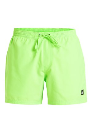 Neon grønne svømmebukser med elastisk talje, justerbar snor og et lille sort logo-patch på venstre nedre side.
