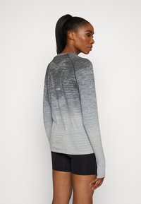 Langærmet gradient top i nuancer af grå, med struktureret stof, en tætsiddende design og fremhævede skuldersømme.