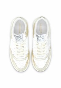 Zapatillas blancas con un upper de cuero suave y detalles en beige, caja de dedo perforada y cordones planos, con insoles y etiquetas de marca.