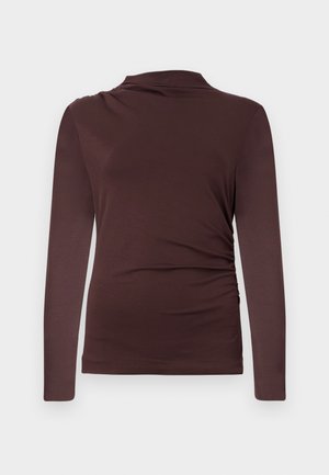 Langermet brun topp med subtil siderykning og en litt drapert utringning, vist mot en enkel lys bakgrunn.
