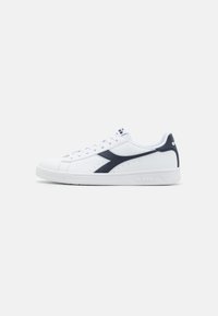 White athletic shoe with navy accents, smooth leather upper, round toe, lace closure, perforated details, and logo on the side and tongue.