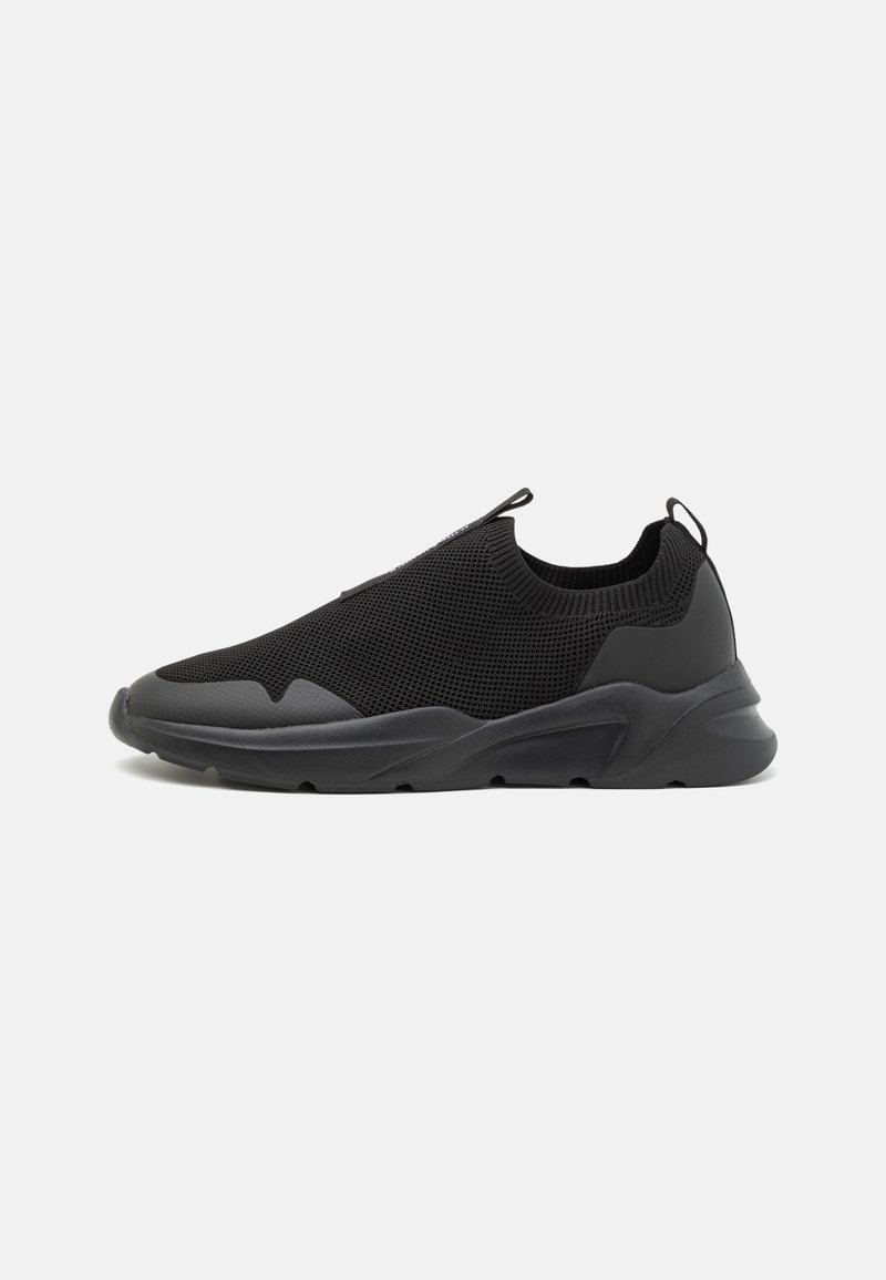Sneakers neri slip-on con tomaia in rete testurizzata, dettagli in gomma e suola spessa dal design elegante e minimalista.