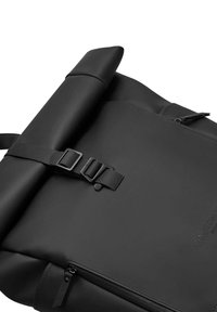 Black roll-top backpack crafted from durable material, featuring adjustable straps, a metal buckle, and a zippered compartment.