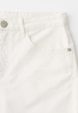 Close-up van het voorzakgebied van witte spijkerbroek met metalen knoop- en klinknageldetails.