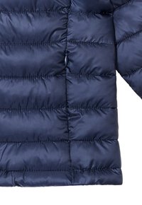 Giacca imbottita blu navy con design trapuntato orizzontale, dotata di una tasca con zip e superficie liscia e lucida.