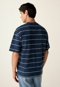 Navyblauwe shirt met korte mouwen met witte horizontale strepen, ronde hals, comfortabele pasvorm, gemaakt van een zachte katoenen mix.