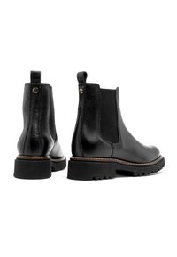 Czarne skórzane botki Chelsea z elastycznymi bokami, zaokrąglonymi noskami i masywnymi gumowymi podeszwami. Posiadają złoty akcent logo oraz brązowe przeszycia.