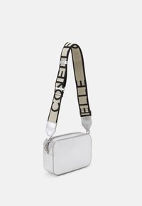 Borsa a tracolla rettangolare argentata in pelle testurizzata, con una ampia tracolla nera con testo "CON", zip in metallo e dettagli argentati.