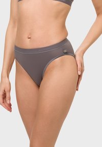 Graue Bikini-Briefs aus einem glatten Material, mit mittlerem Schnitt und elastischem Bund, der mit dezentem Branding und Kontrastnähten akzentuiert ist.