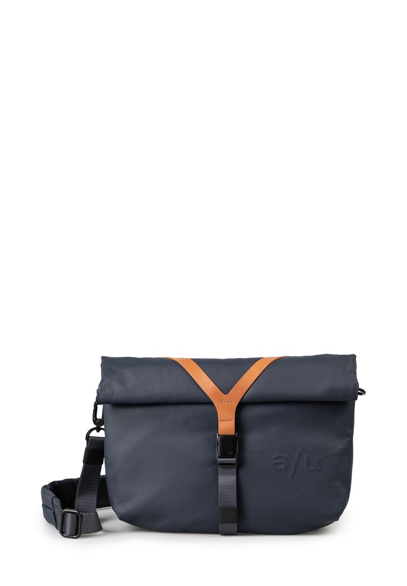 Borsa a rotolo blu realizzata in materiale resistente, con tracolla in pelle marrone, spallaccio regolabile e dettagli del logo impresso.