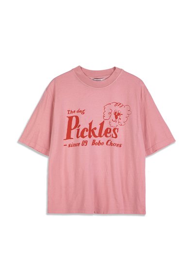 Ružové tričko s krátkym rukávom s červeným textom "Pes Pickles od 09 Bobo Choess" a jednoduchou karikatúrnou tvárou psa na hrudi.