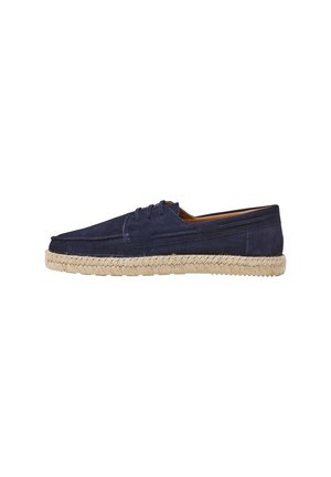 Navy suede shoes with a rounded toe, lace-up design, and a jute rope sole. Features tonal stitching and side detailing.