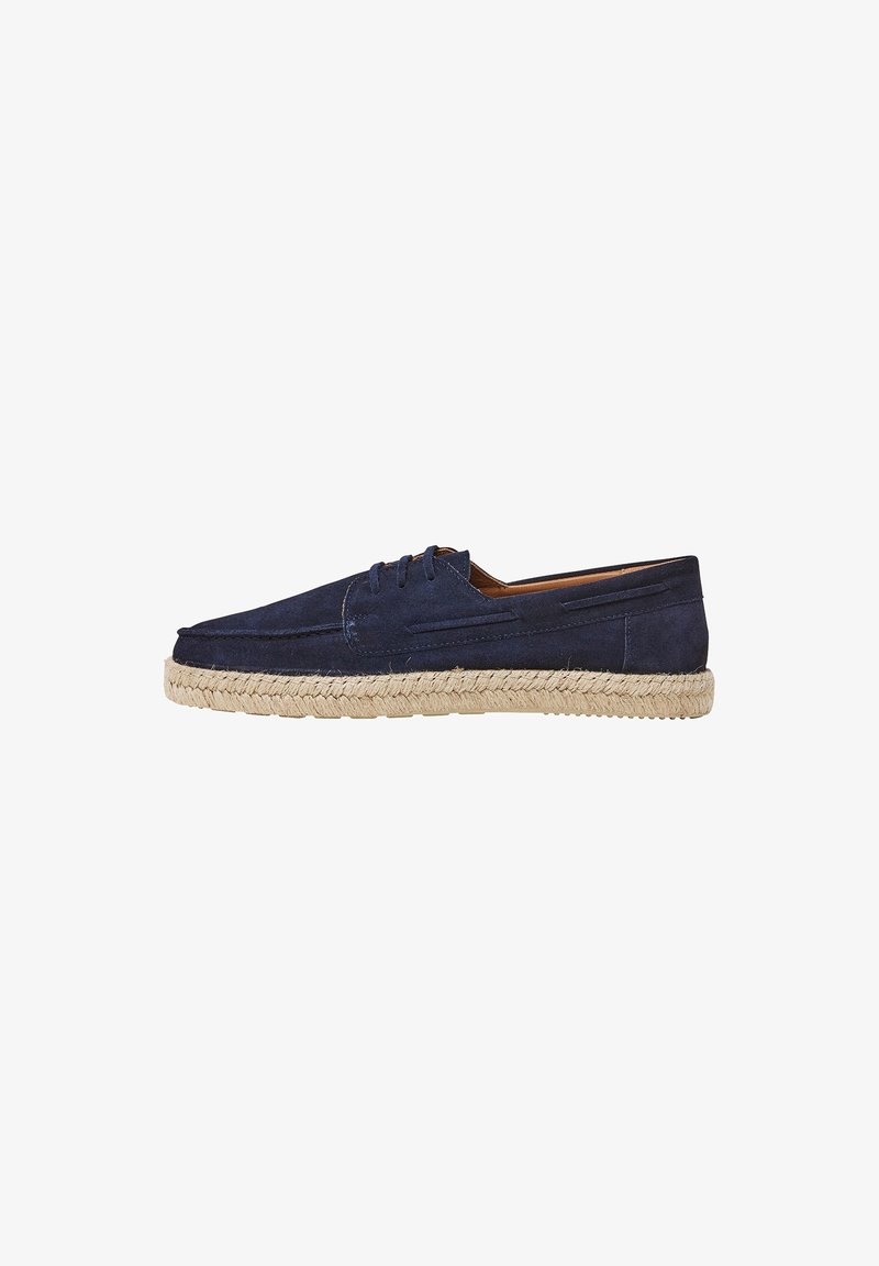 Chaussures en suede bleu marine avec un bout arrondi, un design à lacets et une semelle en corde de jute. Présente des coutures tonales et des détails sur les côtés.