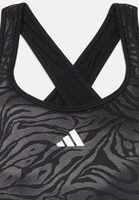 Must mustrin mustriga ristidega, millel on tekstuuriga zeebrahind ja valge logo. Valmistatud sujuvast, venivast materjalist.