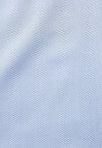Tessuto di un blu chiaro con texture, caratterizzato da un motivo fine, superficie liscia e distribuzione uniforme del colore, adatto per diverse applicazioni tessili.