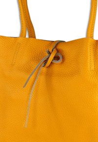 Gelbe Leder-Shopper-Tasche mit strukturierter Oberfläche, ausgestattet mit einem oben zusammengezogenen Rand und grauen Bändern zum Verschließen. Glatte Griffe ergänzen das Design.