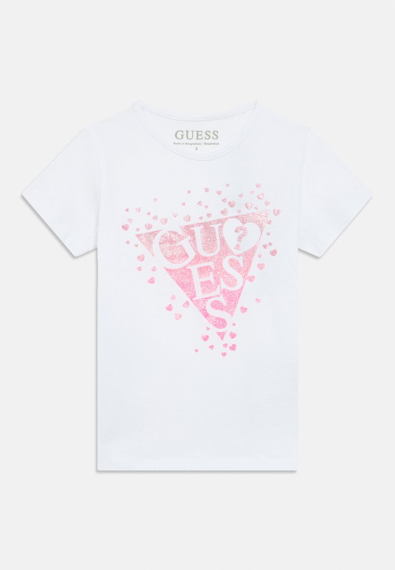 Balta īsroku T-krekls ar lielu rozā spīdīgu trijstūra dizainu, kurā redzams vārds "GUESS" un izkaisīti mazi rozā sirsniņas.