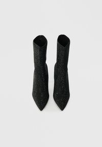 Μαύρες ankle boots με μυτερή μύτη, υφασμάτινες με υφή καλυμμένες με λαμπερούς ρουμπινίτες, που διαθέτουν κομψό και εφαρμοστό σχέδιο με υψηλό μπούστο.