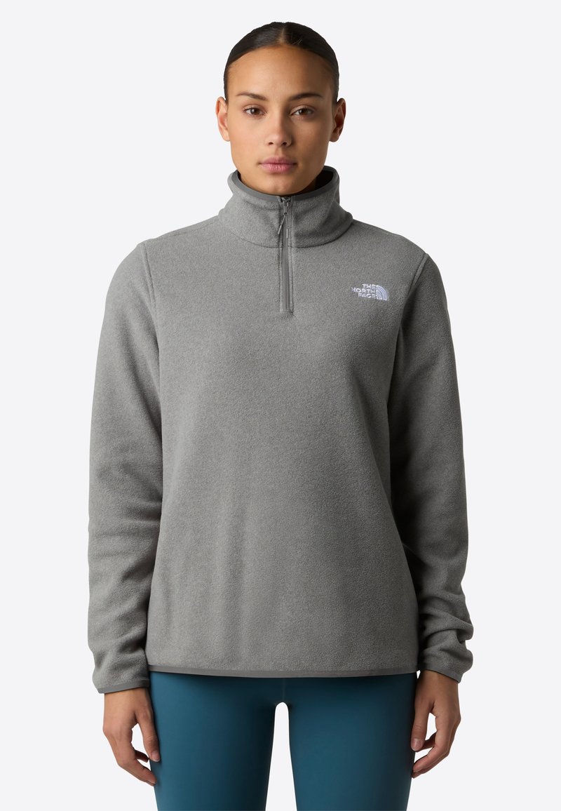 Pullover grigio in pile con colletto alto e chiusura a zip quarti. Presenta un piccolo logo bianco sul lato sinistro del petto. Tessuto morbido, vestibilità rilassata.