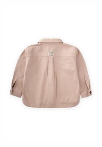 Camicia a maniche lunghe color beige chiaro con colletto, piega posteriore e polsini con bottone. Presenta un'etichetta quadrata sulla parte superiore della schiena.