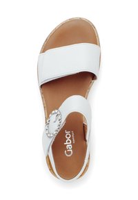 Weiße Ledersandale mit zwei breiten Riemen, einem runden Metallelement und einer korkähnlichen Sohle. Verfügt über ein braunes strukturiertes Fußbett.