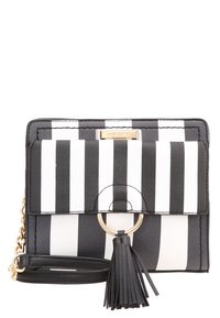 Borsa a tracolla in finta pelle a righe bianche e nere con chiusura a pattina, anello in metallo dorato e una frangia decorativa su un cinturino staccabile.