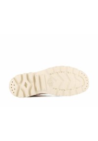 Semelle de sneaker blanche avec de profonds rainures et un motif texturé, présentant un accent en forme de losange et des trous de ventilation circulaires.