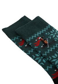 Zaļas adītas zeķes ar rakstainu dizainu, kas attēlo sniega kutinātājus un slēpotāju sarkanā krāsā. Izgatavotas no mīksta auduma ar ribotām apkaklēm.