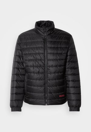 Svart pufferjakke med horisontale quiltede paneler, høy krage, frontglidelås og elastiske mansjetter. Rødt "HUGO"-logo nederst til venstre.