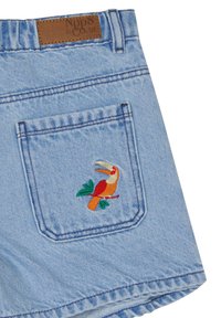 Hellblaue Jeansshorts mit einer Gesäßtasche, die mit einem gestickten Tukankunstwerk in lebendigen Farben und grünen Blattakzenten verziert ist.