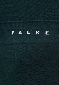 Dunkelgrüner Stoff mit dem Markennamen "FALKE" in weißen Buchstaben. Das Material hat eine glatte Textur mit dezenten Musterdetails.
