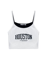 Biały krótki top z czarnym dekoltem, na którym znajduje się duży czarny nadruk z napisem "HOUSTON TEXAS" oraz dwiema gwiazdkami poniżej tekstu.
